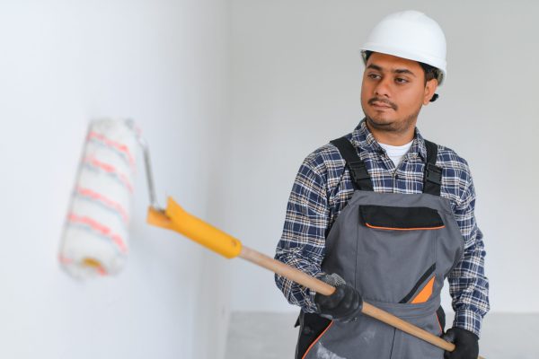 Indian worker makes repairs in an apartment.